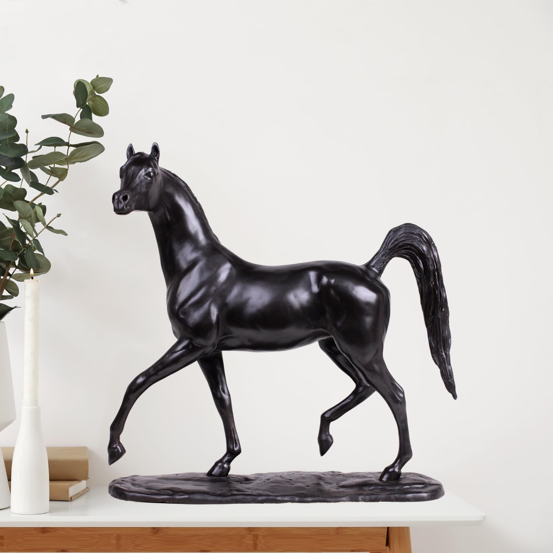 Midnight black Arabian stallion bronze sculpture displayed on shelf beside indoor plant