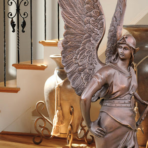 Classic bronze Bellona winged goddess statue in outdoor garden setting with natural backdrop