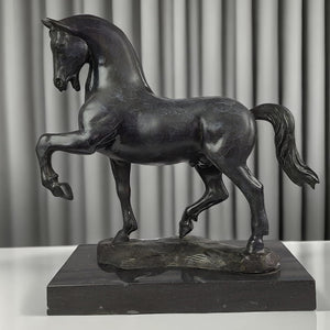 Black bronze striding stallion statue front angle view displayed with curtain background