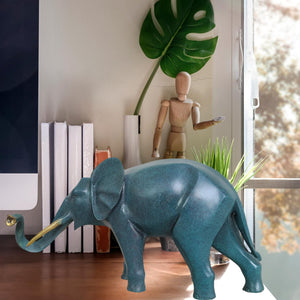 Blue bronze elephant statue in entryway decor setting beside chair and indoor plant