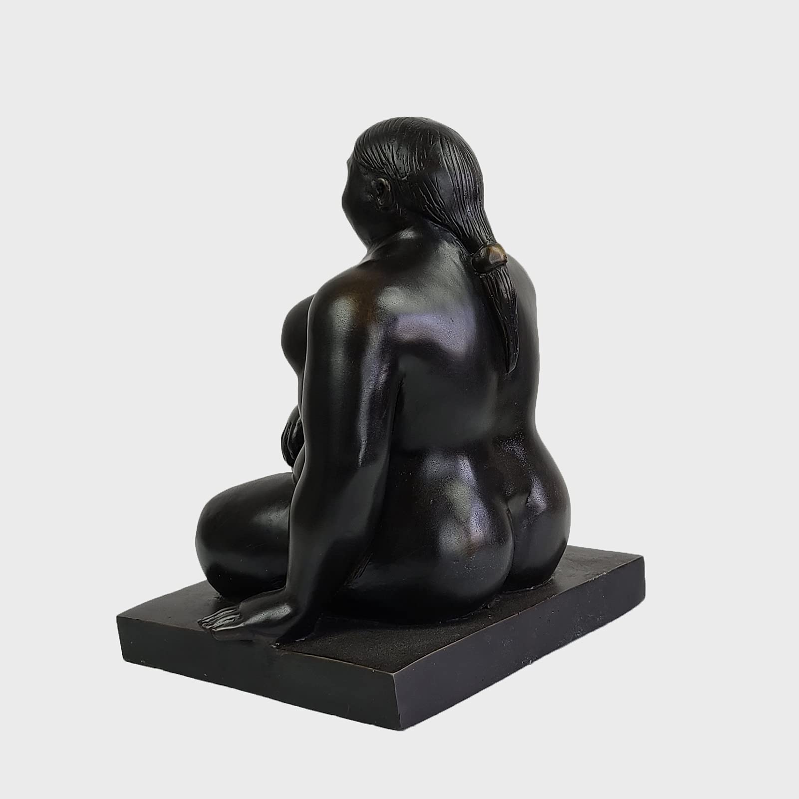Botero bronze seated woman sculpture three quarter angle dark background