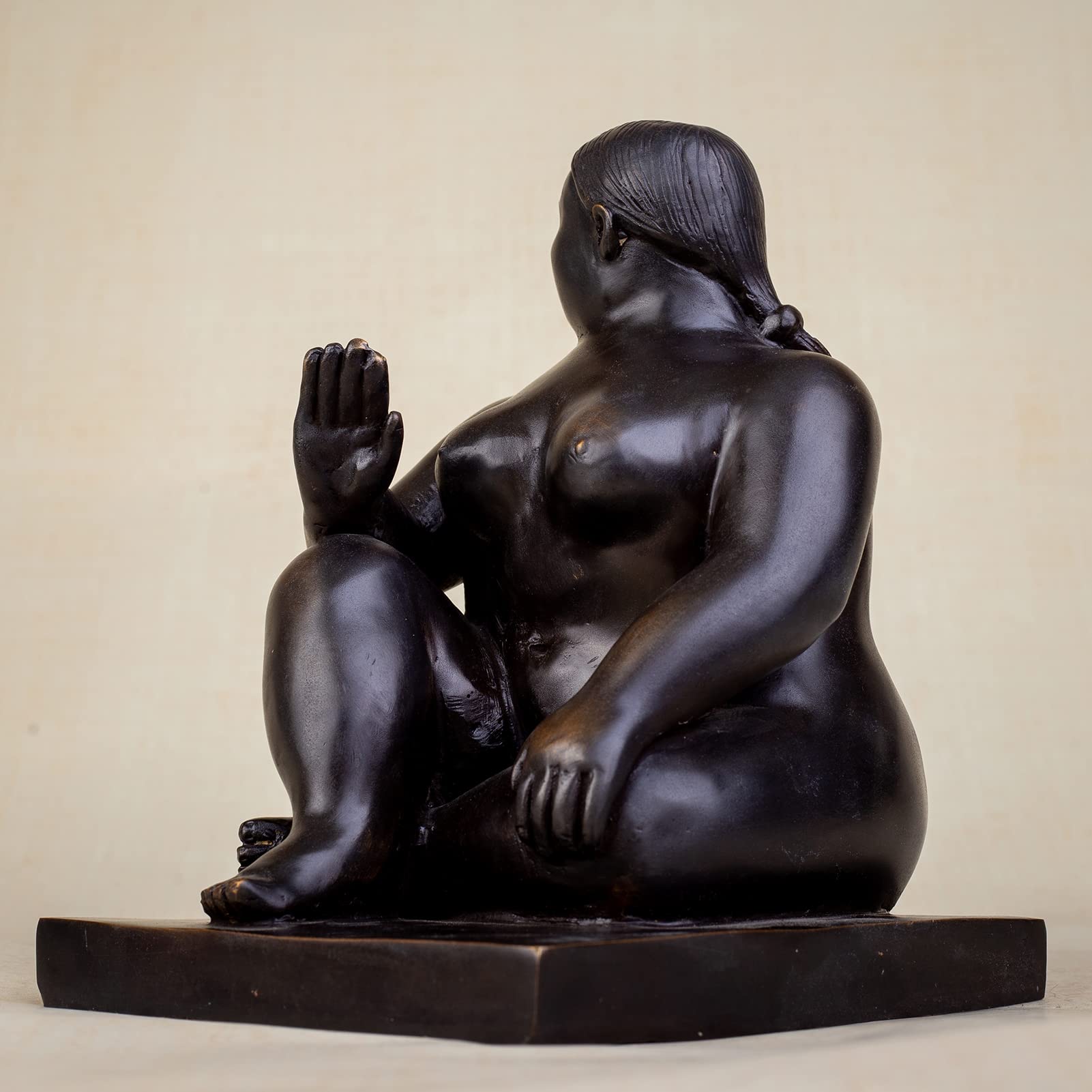 Left angle view of seated voluptuous lady bronze meditation statue on rectangular base