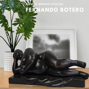 Botero style bronze reclining woman statue displayed in living room with plant