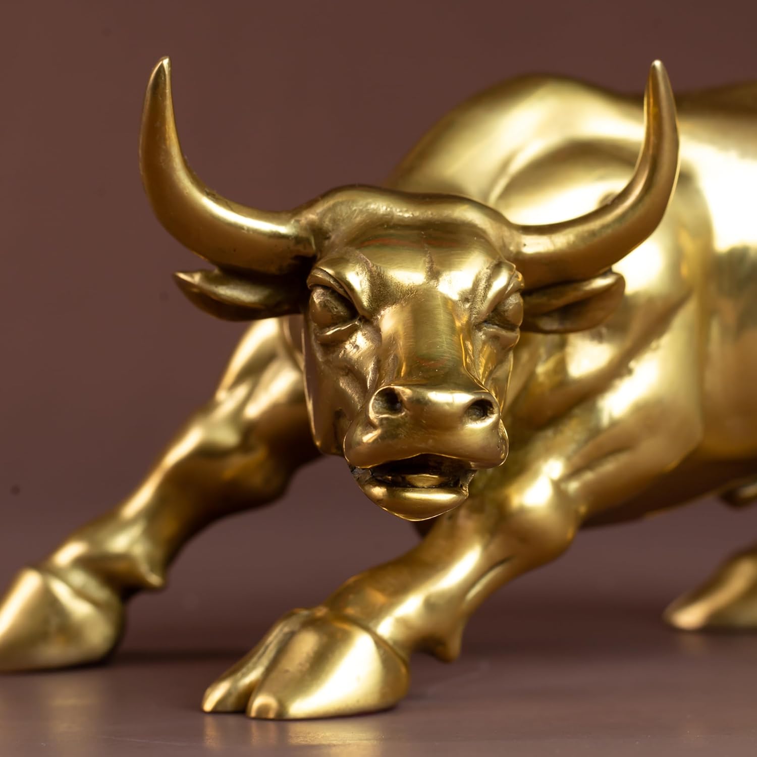 Front close-up of the golden brass bull figurine horn detail.