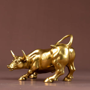 Side profile of the golden brass charging bull sculpture.