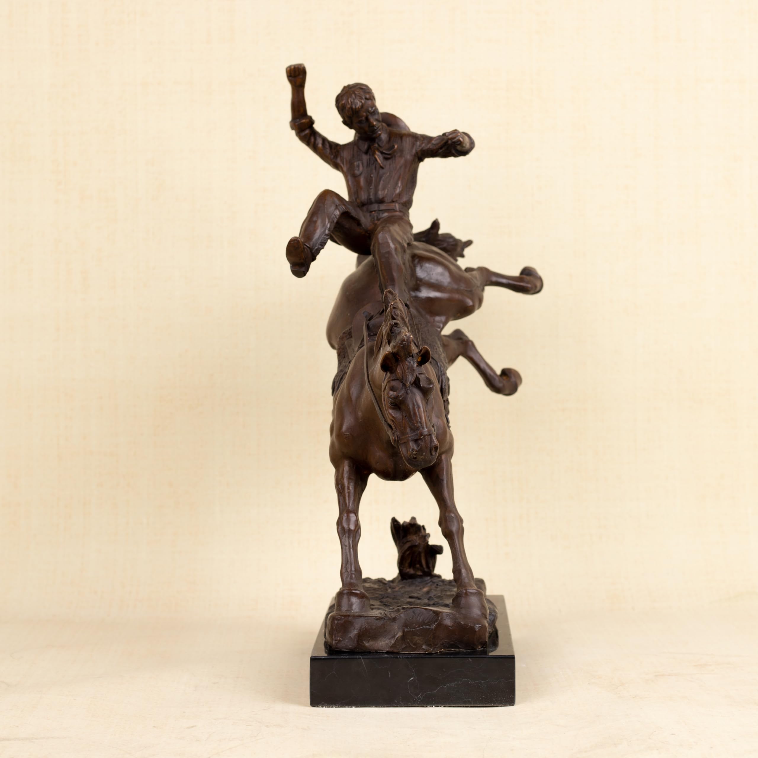 Side view of Bronco Buster bronze bucking combat sculpture showing cowboy raising arm above rearing horse