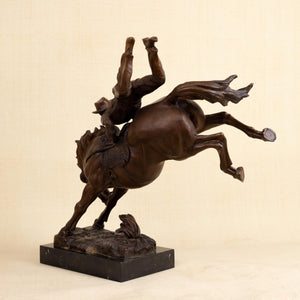 Top angle view of large Bronco Buster bronze sculpture highlighting cowboy figure detail and saddle