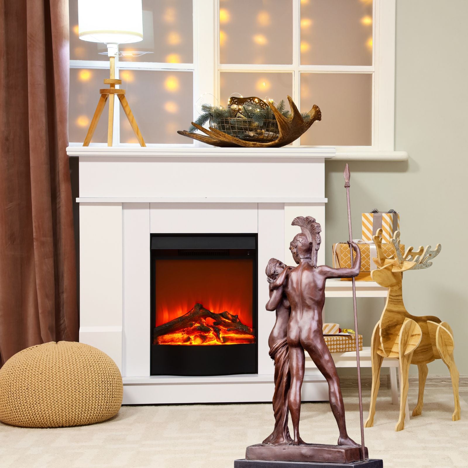 Bronze Ares and Aphrodite sculpture displayed beside fireplace in warm holiday interior setting