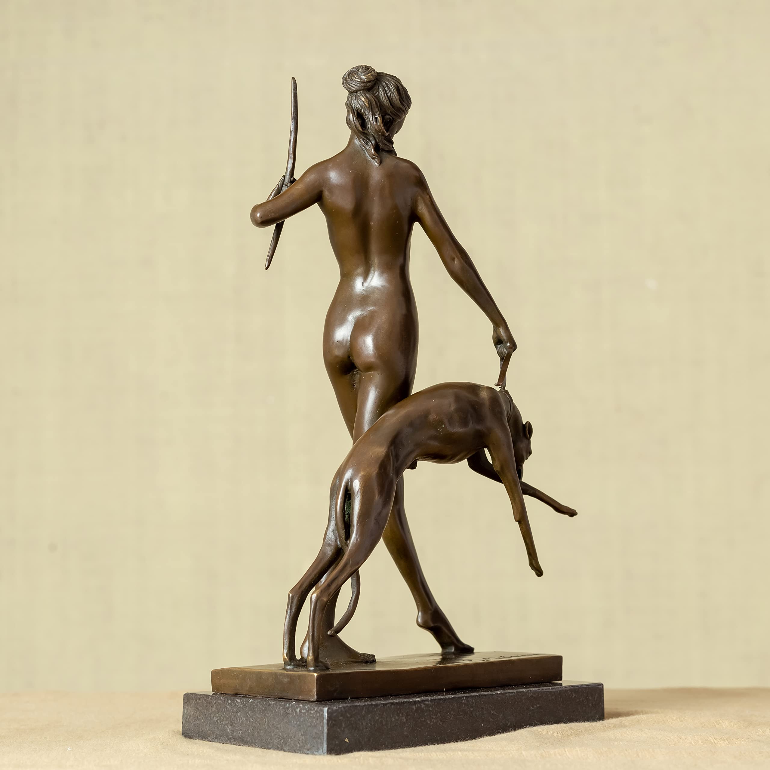 Front close-up of bronze Artemis Greek goddess statue in standing pose holding spear with greyhound