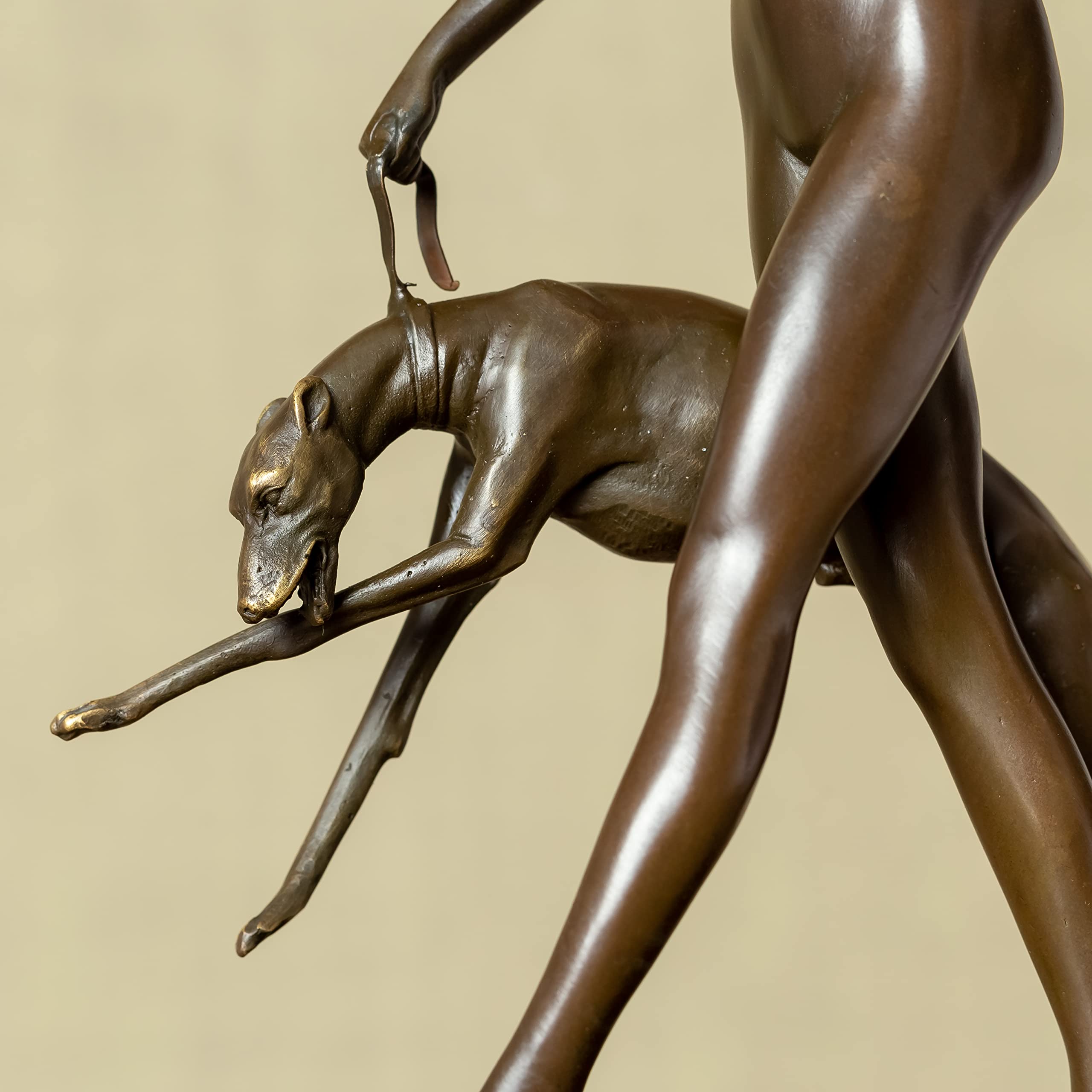 Close-up detail of bronze Artemis huntress goddess interacting with greyhound sculpture