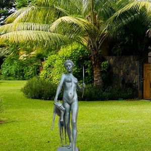 Large bronze Artemis huntress statue displayed in tropical garden outdoor setting
