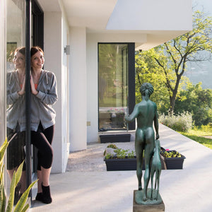 Bronze Artemis huntress statue at building entrance showing human scale comparison