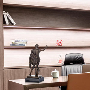 Bronze Augustus Caesar statue displayed on modern bookshelf in office interior setting