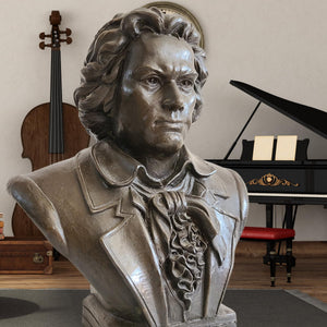 Bronze Beethoven bust statue displayed alongside violin and piano in music-themed setting