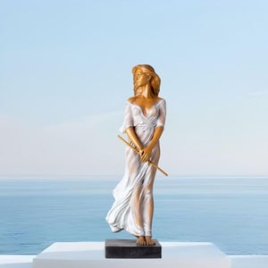 Bronze elegant woman with flute statue flowing sheer gown full view ocean backdrop