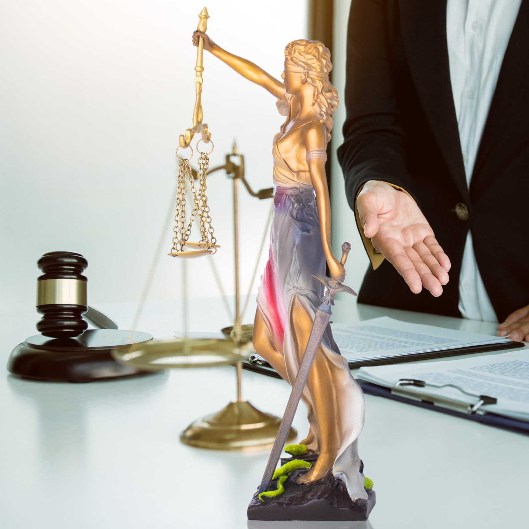 Bronze Lady Justice Themis statue in law firm office with law books and gavel display