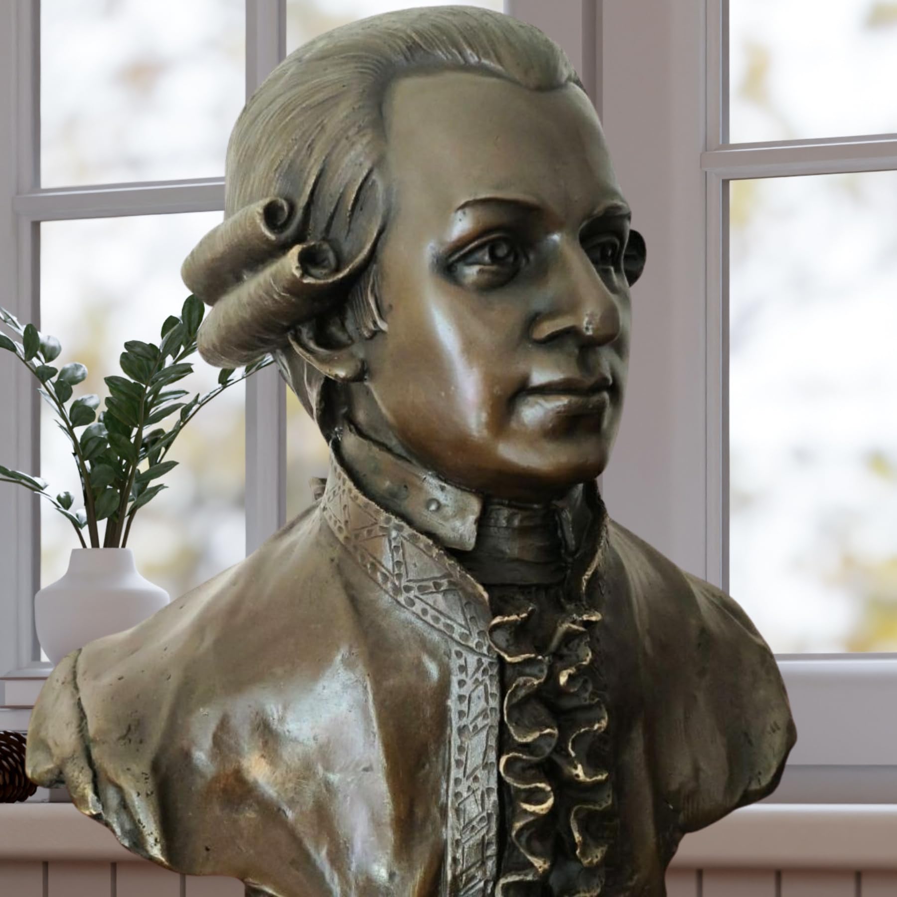 Close-up side view of bronze Mozart bust statue showing period costume collar detail