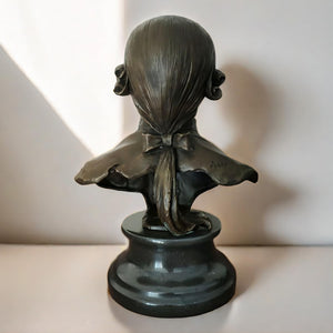 Bronze Mozart bust statue displayed by window with plant decor lifestyle setting