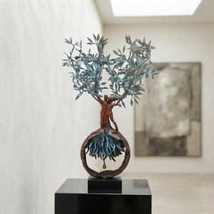 The 1.2-meter-tall handcrafted bronze olive tree and embracing couple sculpture placed on a sleek black display pedestal inside a minimalist art gallery with soft natural lighting and concrete walls.
