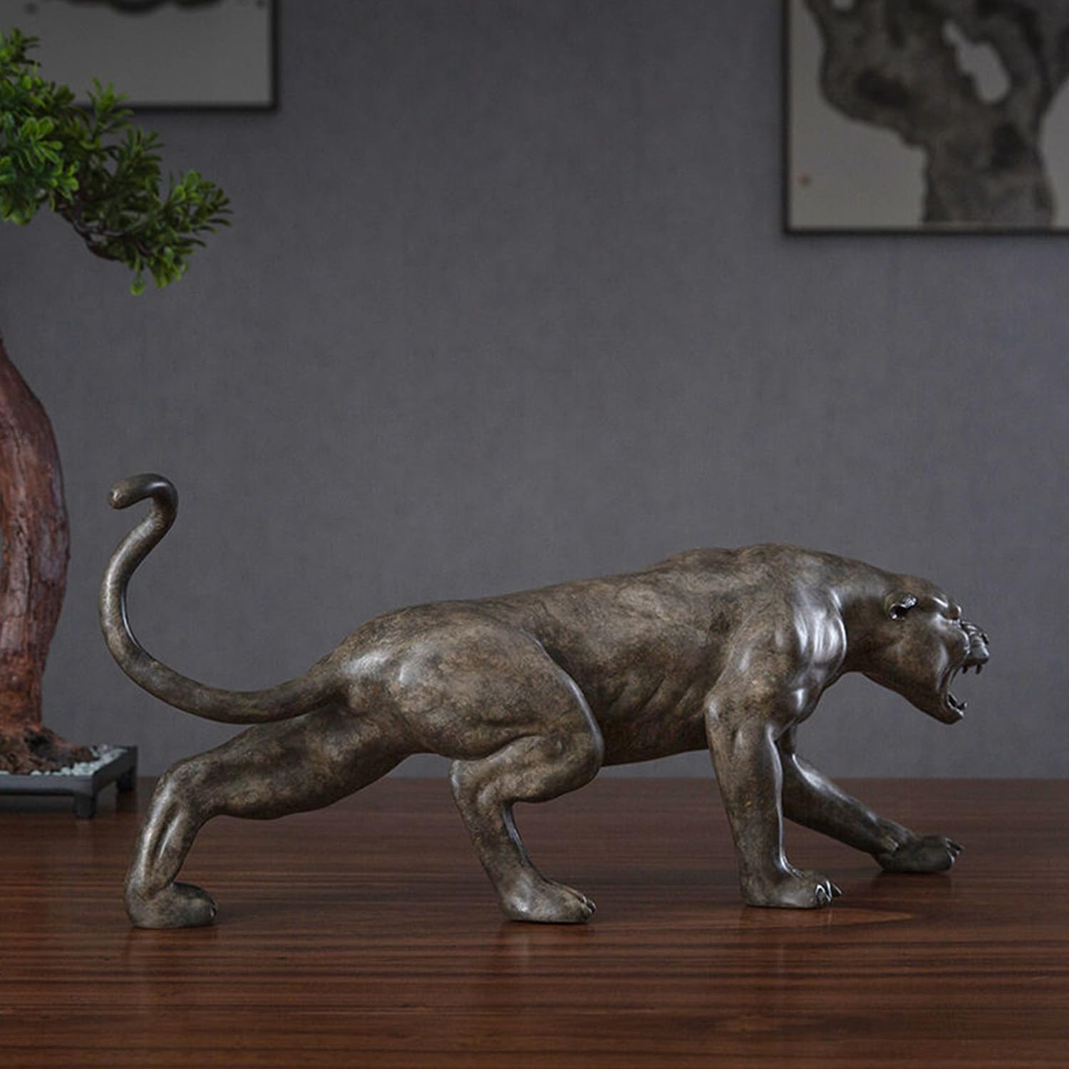 Angled view of bronze predator panther sculpture on wooden surface in indoor office decor setting