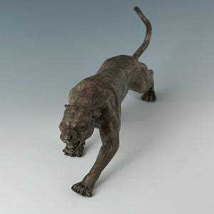 Close-up detail of bronze stalking panther statue with open roaring mouth and textured surface