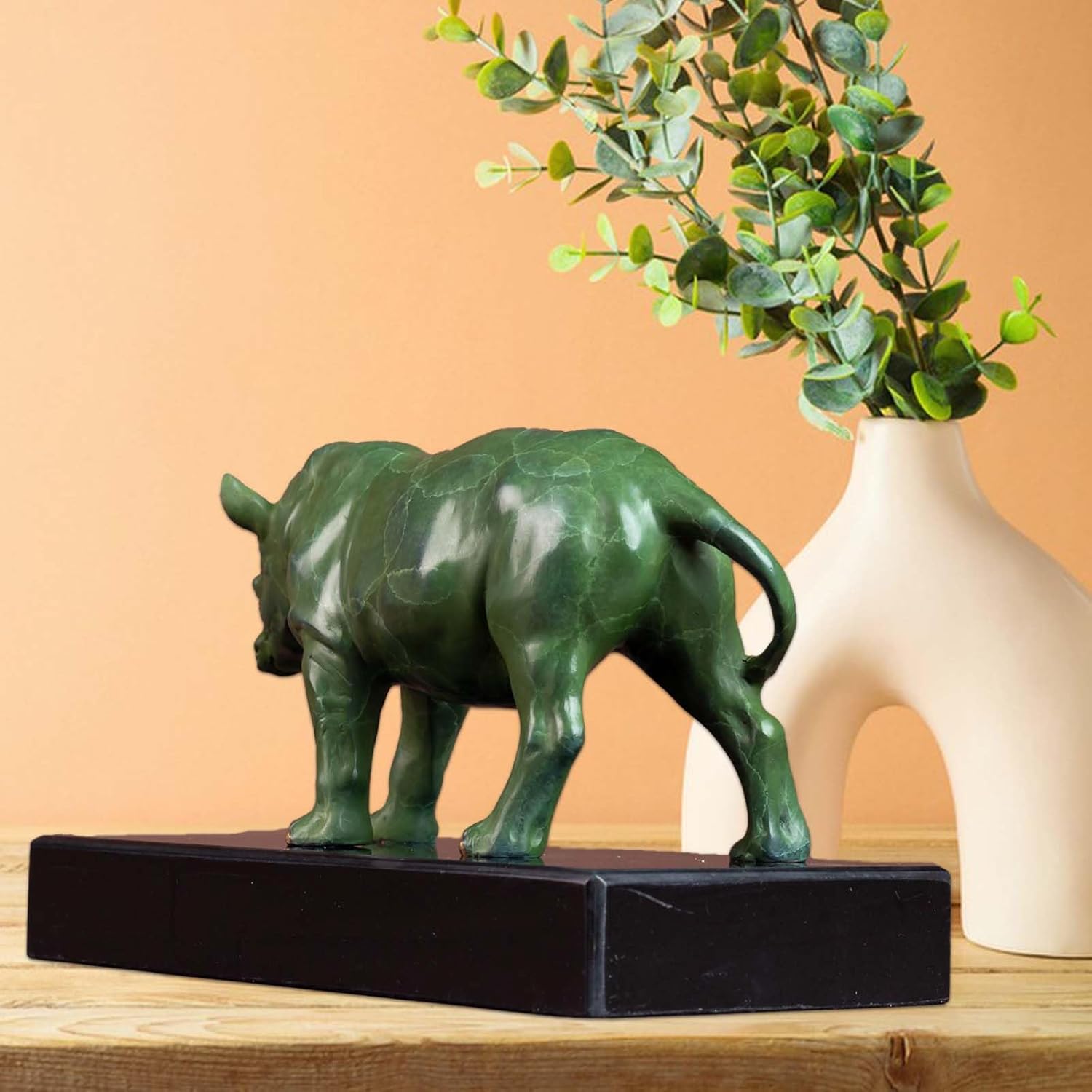 Bronze rhino figurine on black base, styled in a modern home office setting.
