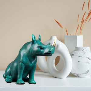 Bronze rhino decor styled with modern vases in home interior.