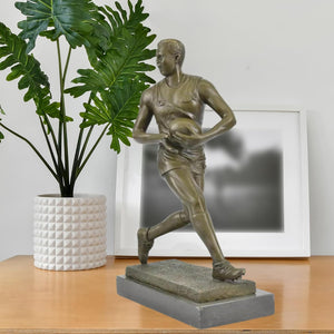 Bronze rugby player sculpture displayed in modern living room as sports décor centerpiece