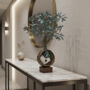Handmade bronze olive tree decor piece styled on a luxury marble console table in a high-end hallway.