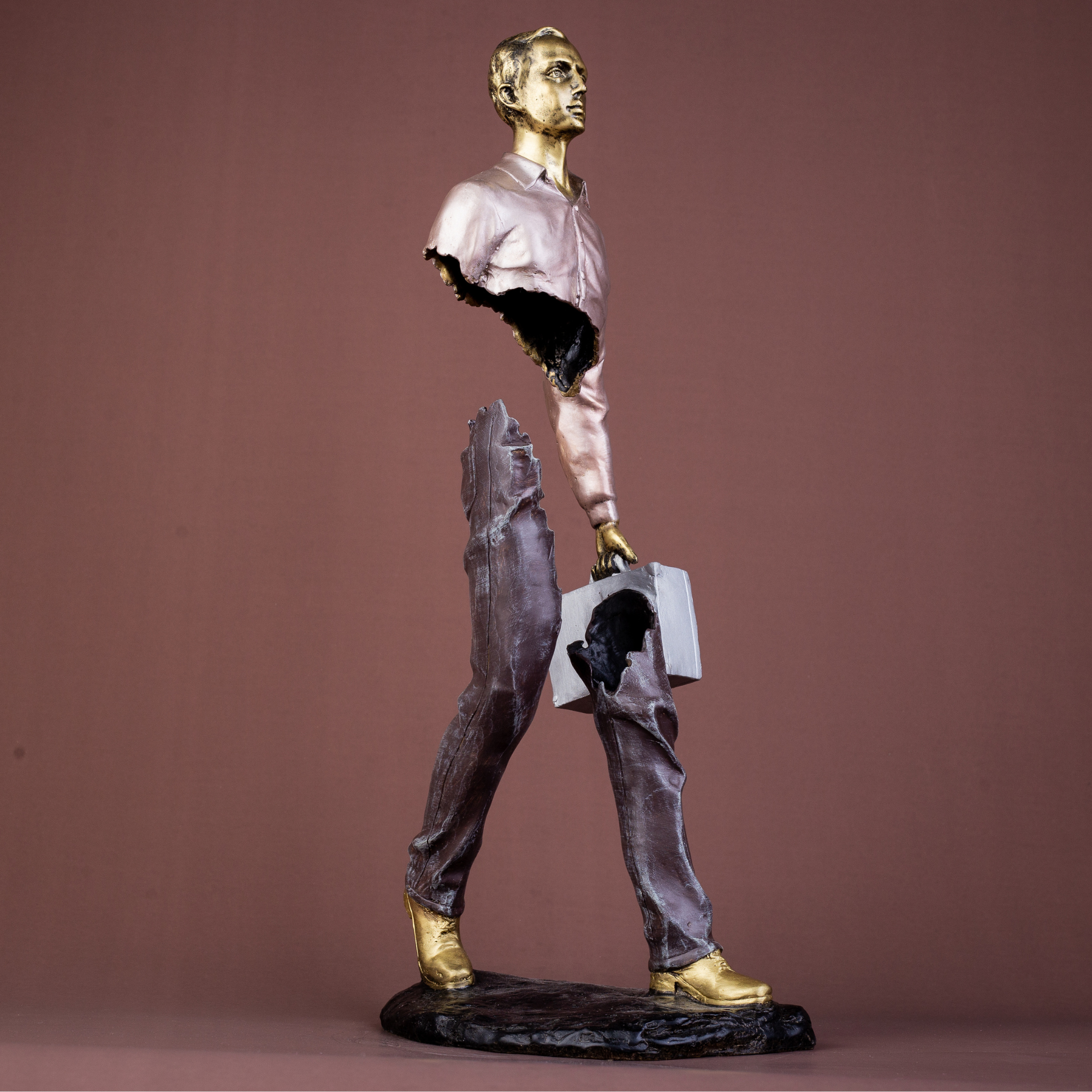 Detail shot of the silver suitcase held by the bronze traveler art piece