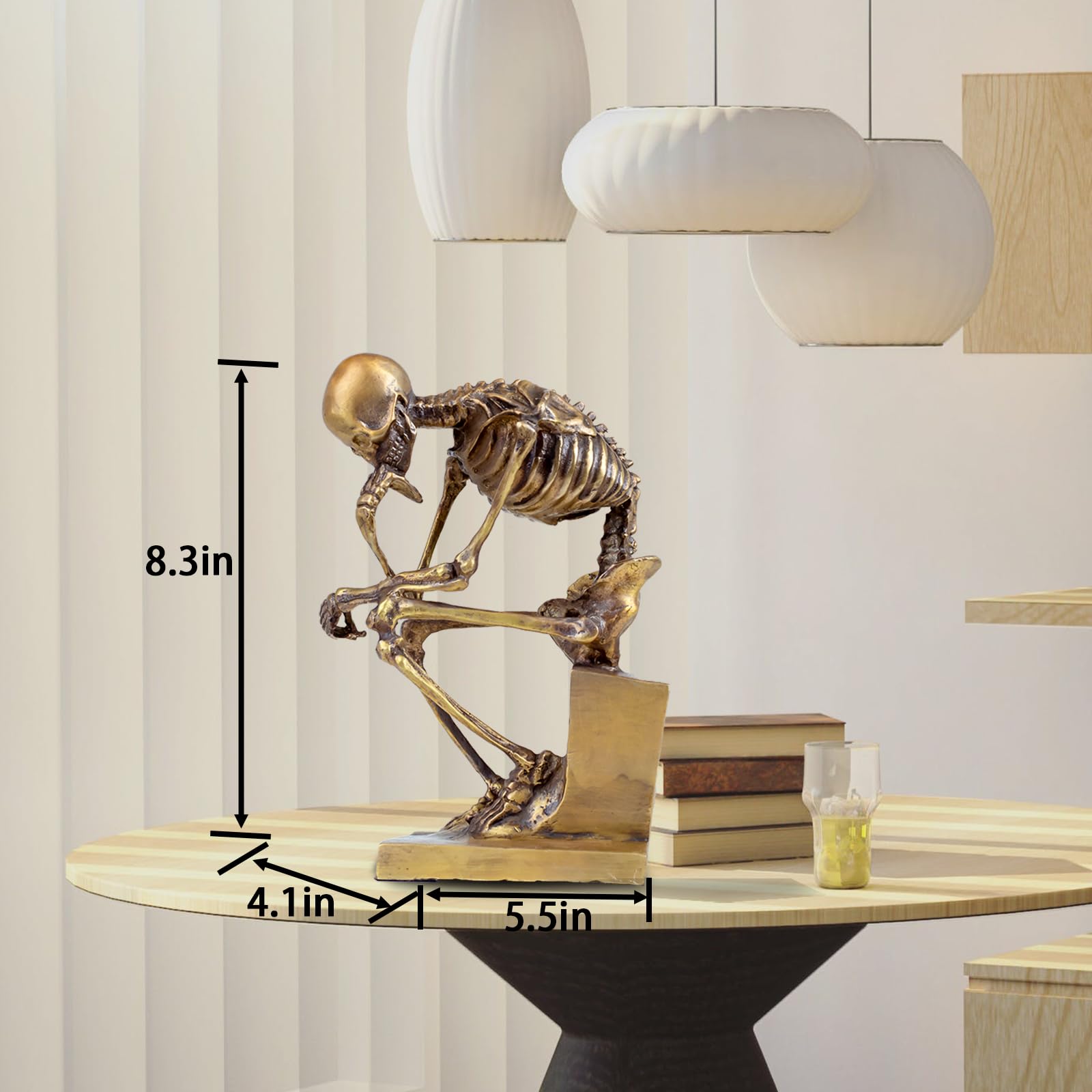Bronze skeleton Thinker statue in gold finish displayed in modern minimalist interior setting