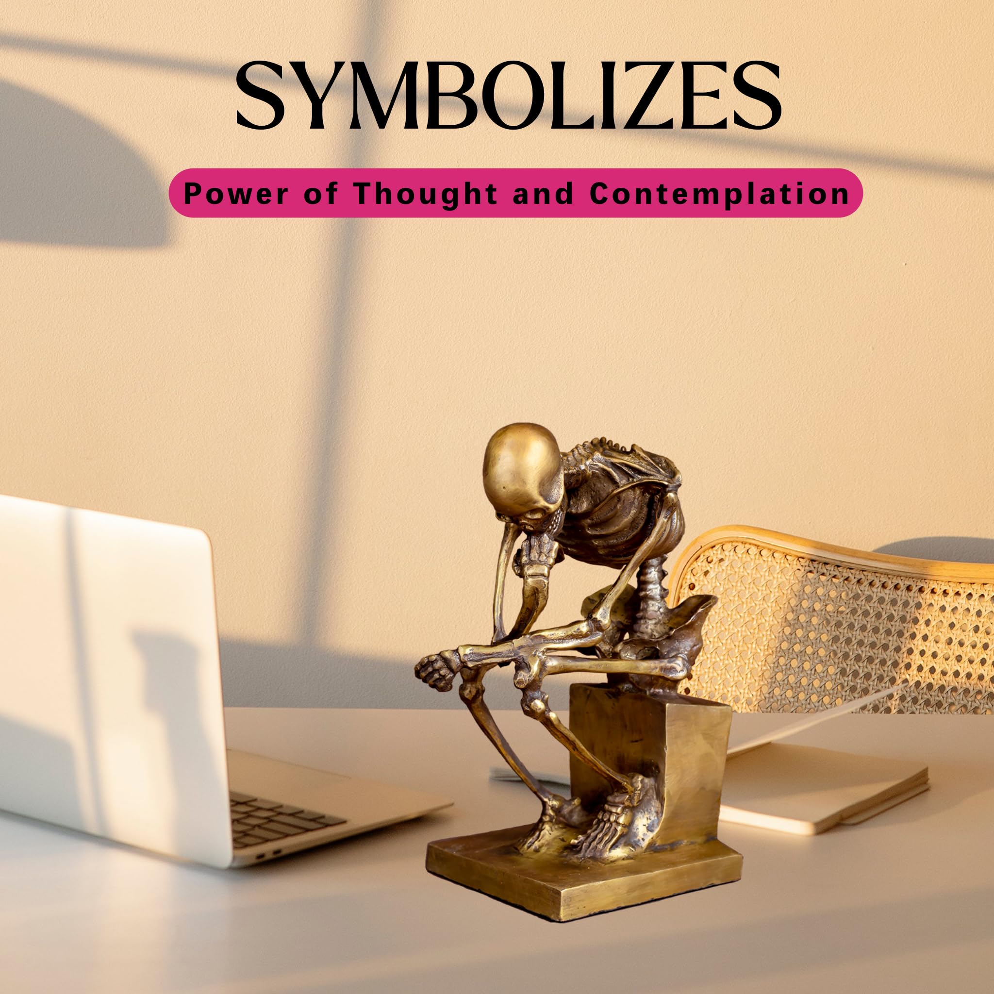 Bronze skeleton Thinker statue in gold finish symbolizes thought feature beside laptop