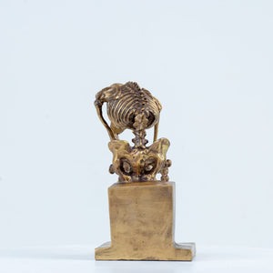 Bronze skeleton Thinker statue in gold finish three-quarter angle view on white background