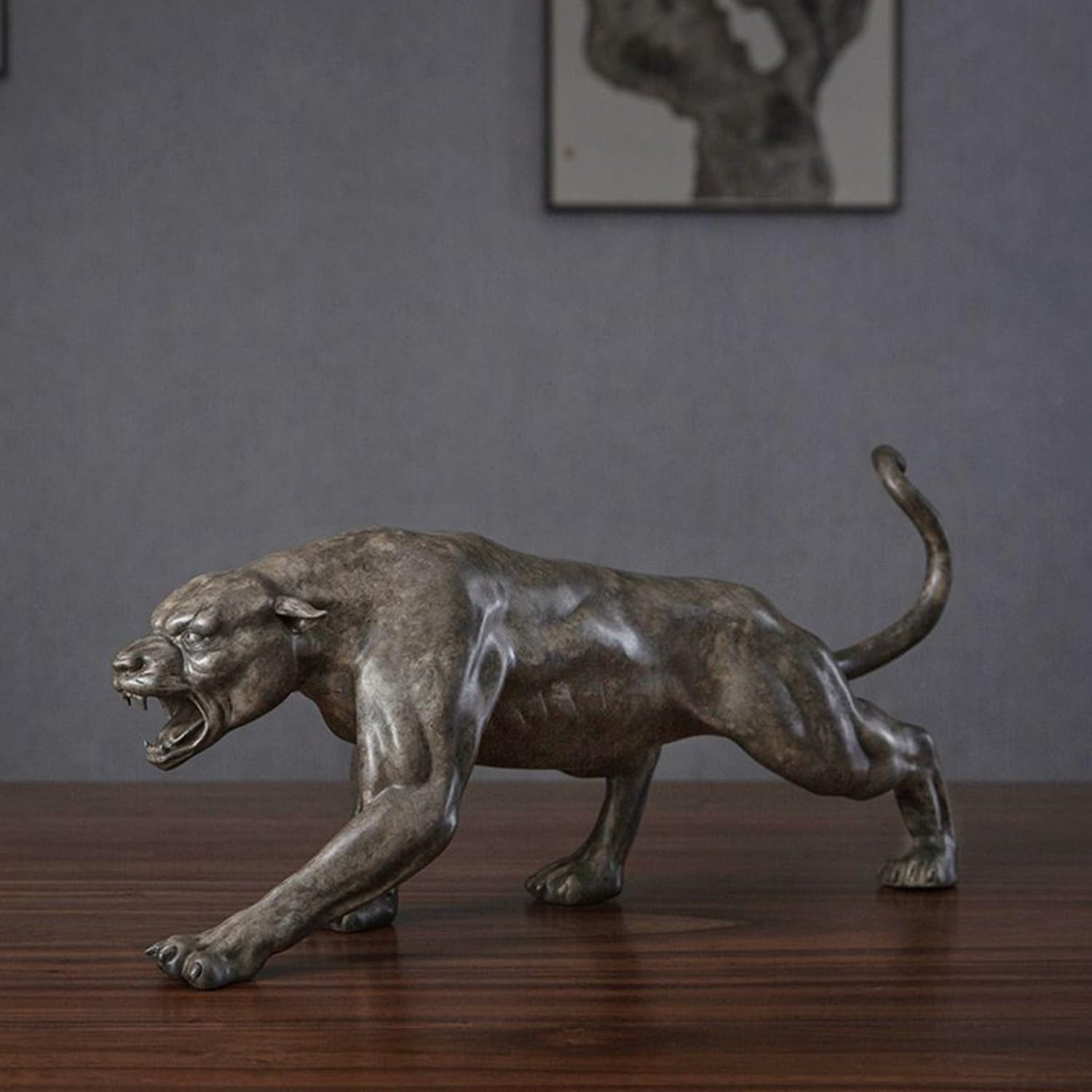 Bronze stalking panther statue displayed on indoor wooden desk as executive office decor
