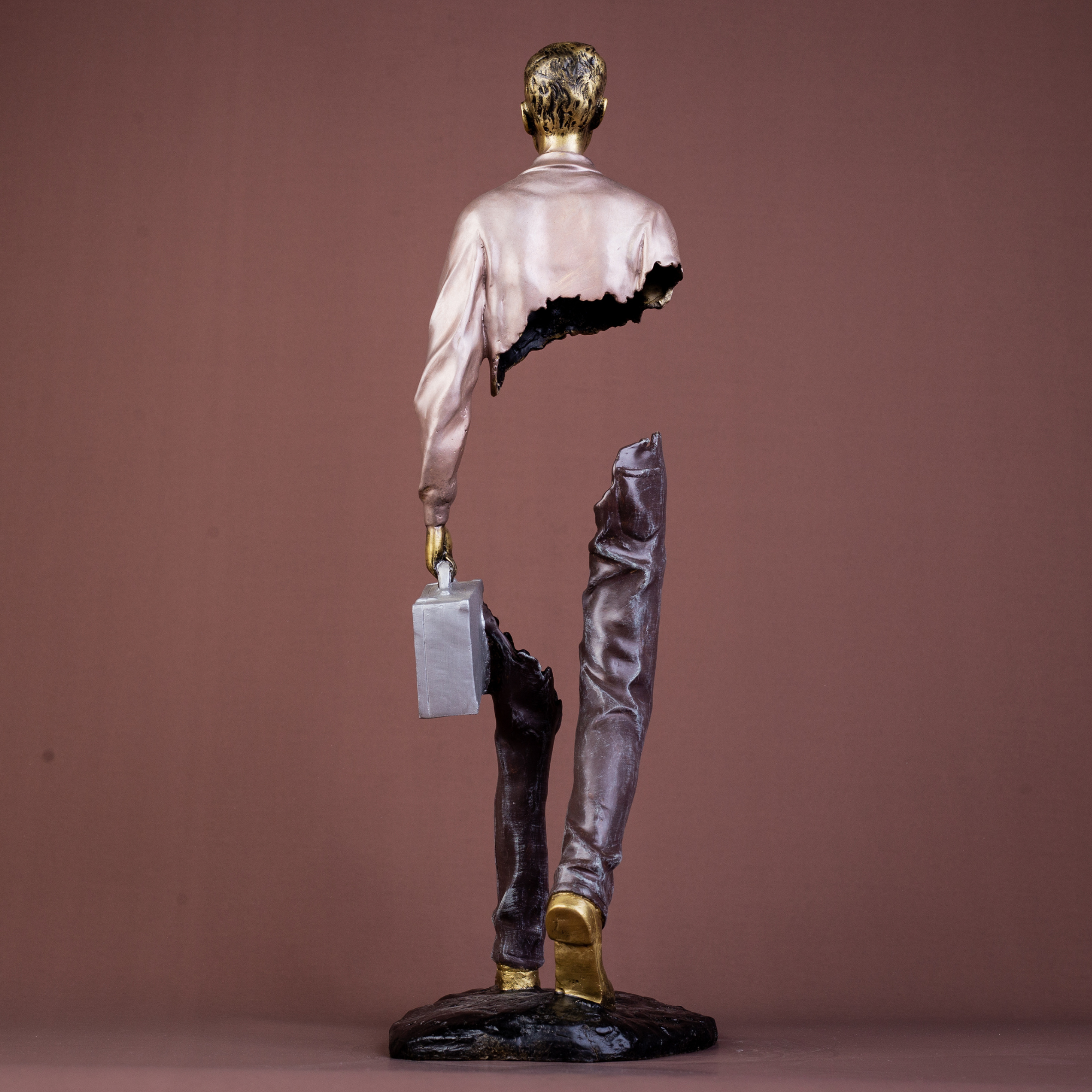 Close-up of the textured bronze legs and integrated base of the traveler sculpture.
