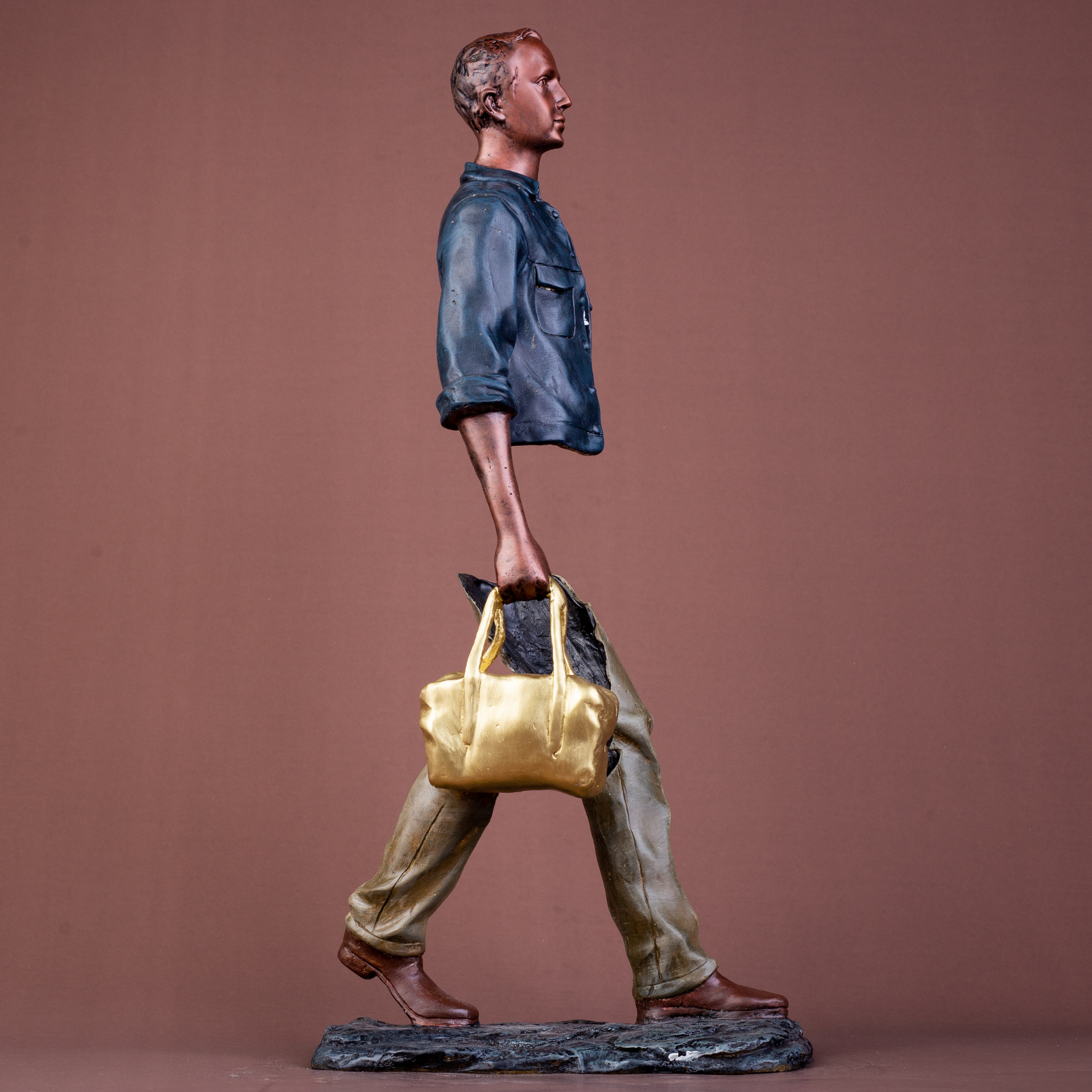 Close-up of the detailed facial features and polished bronze finish of the traveler statue.