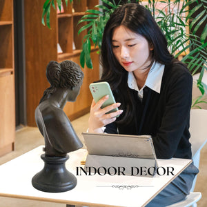 Woman holding bronze Venus de Milo bust statue showing indoor decor lifestyle setting