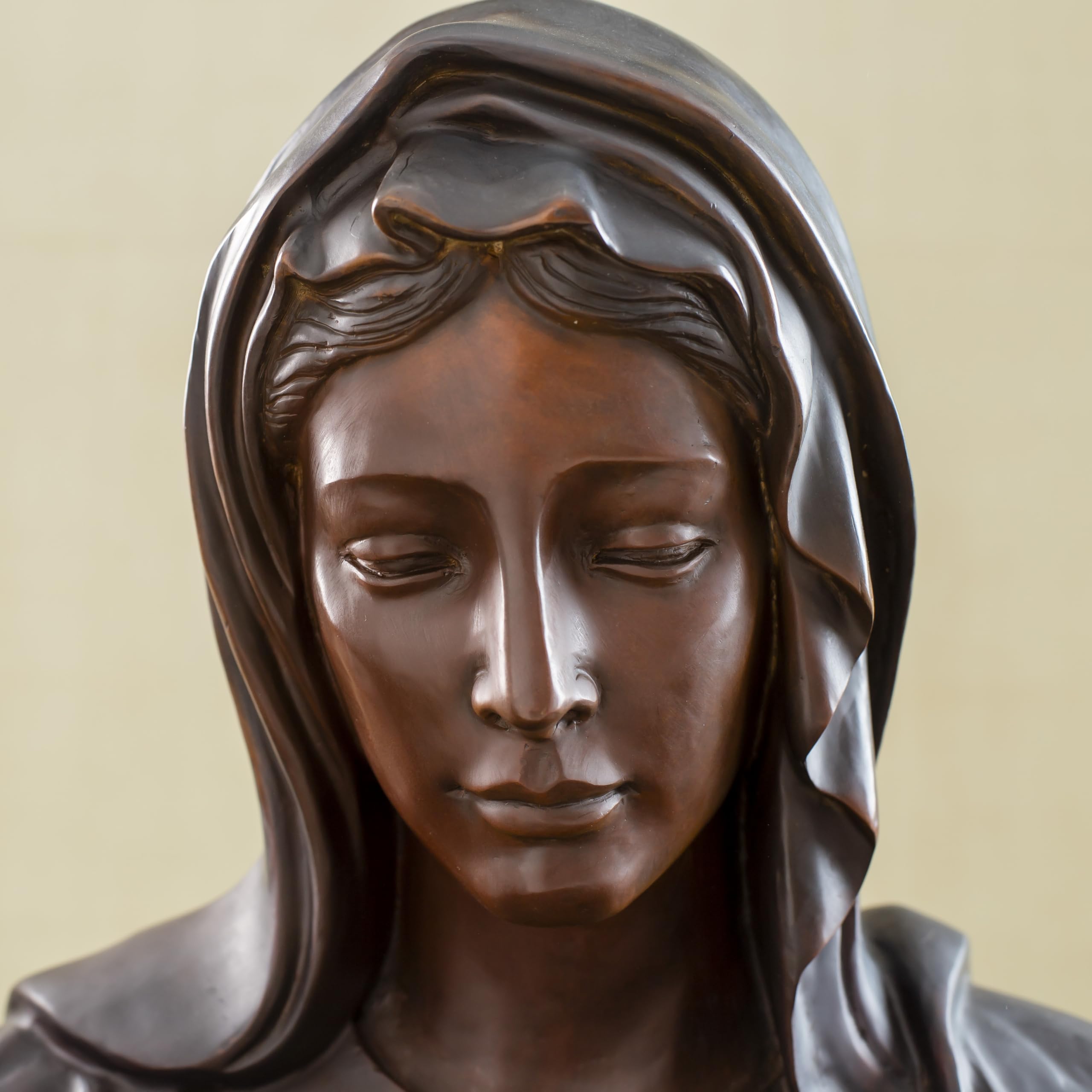Close-up front detail of bronze Virgin Mary bust statue showing serene facial expression and veil