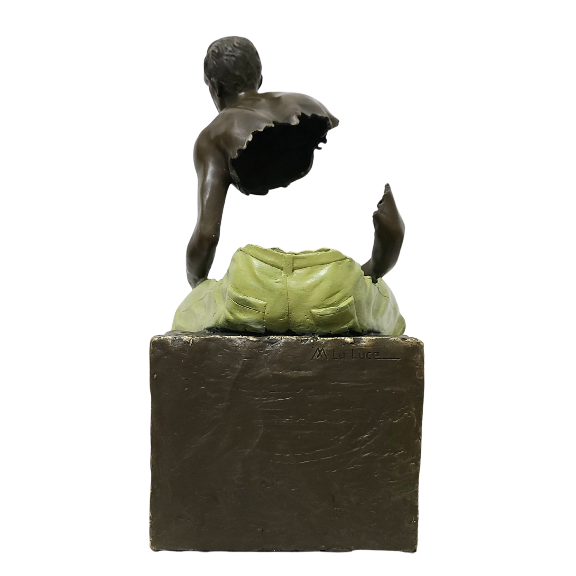 Low angle view of seated bronze fragmented traveler sculpture showing cube base and figure