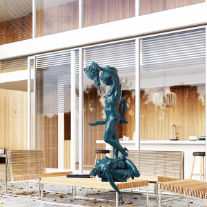 Large blue verdigris Perseus Medusa bronze statue displayed beside fireplace in luxury interior