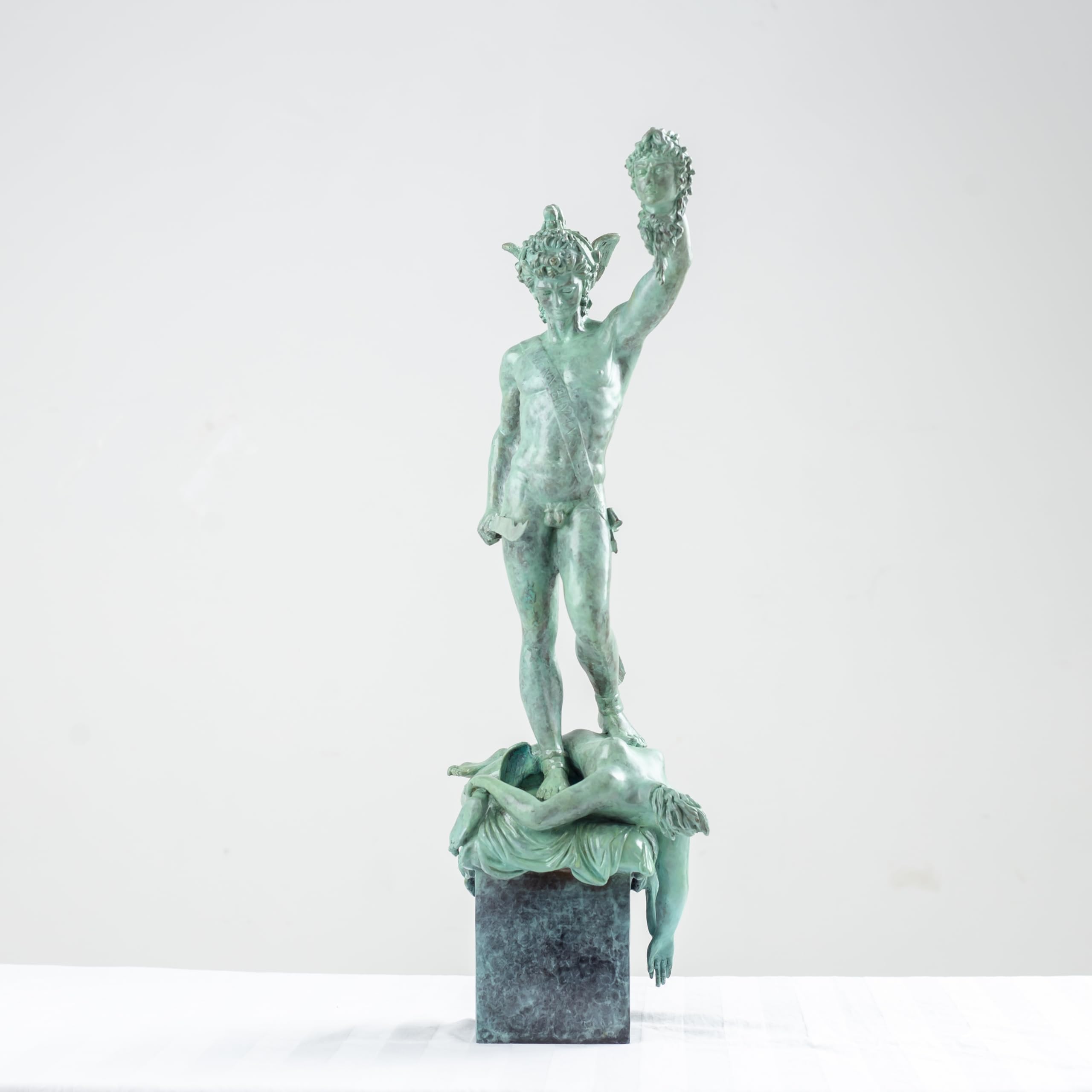 Angled view of Perseus Medusa green bronze sculpture showing mythological figure detail