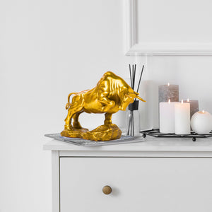 Detailed view of the rocky base for golden yellow bull statue.
