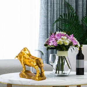 Golden yellow bull figurine styled on an executive office desk.