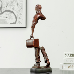 Close-up shot of the bronze briefcase and hand-cast detailing on the traveler figurine.
