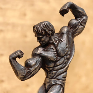 Close-up of dark patina bodybuilder bronze sculpture highlighting detailed muscle anatomy