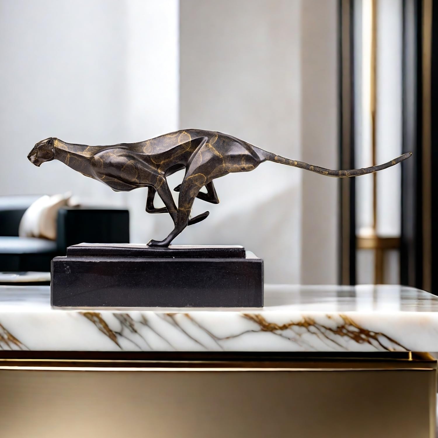Dark bronze running cheetah sculpture on black marble base displayed on marble table luxury interior