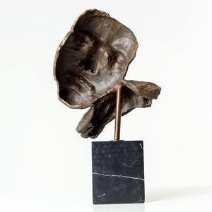 Low angle view of Deep Reflection bronze thinker sculpture highlighting marble base and figure