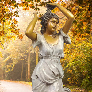 Demeter goddess bronze statue in autumn outdoor setting beside trees with warm seasonal foliage