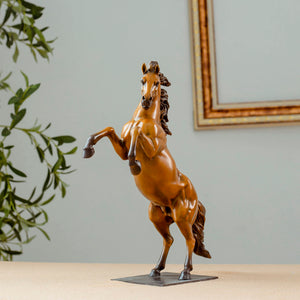 Gold bronze rearing stallion desk edition sculpture displayed with framed art background
