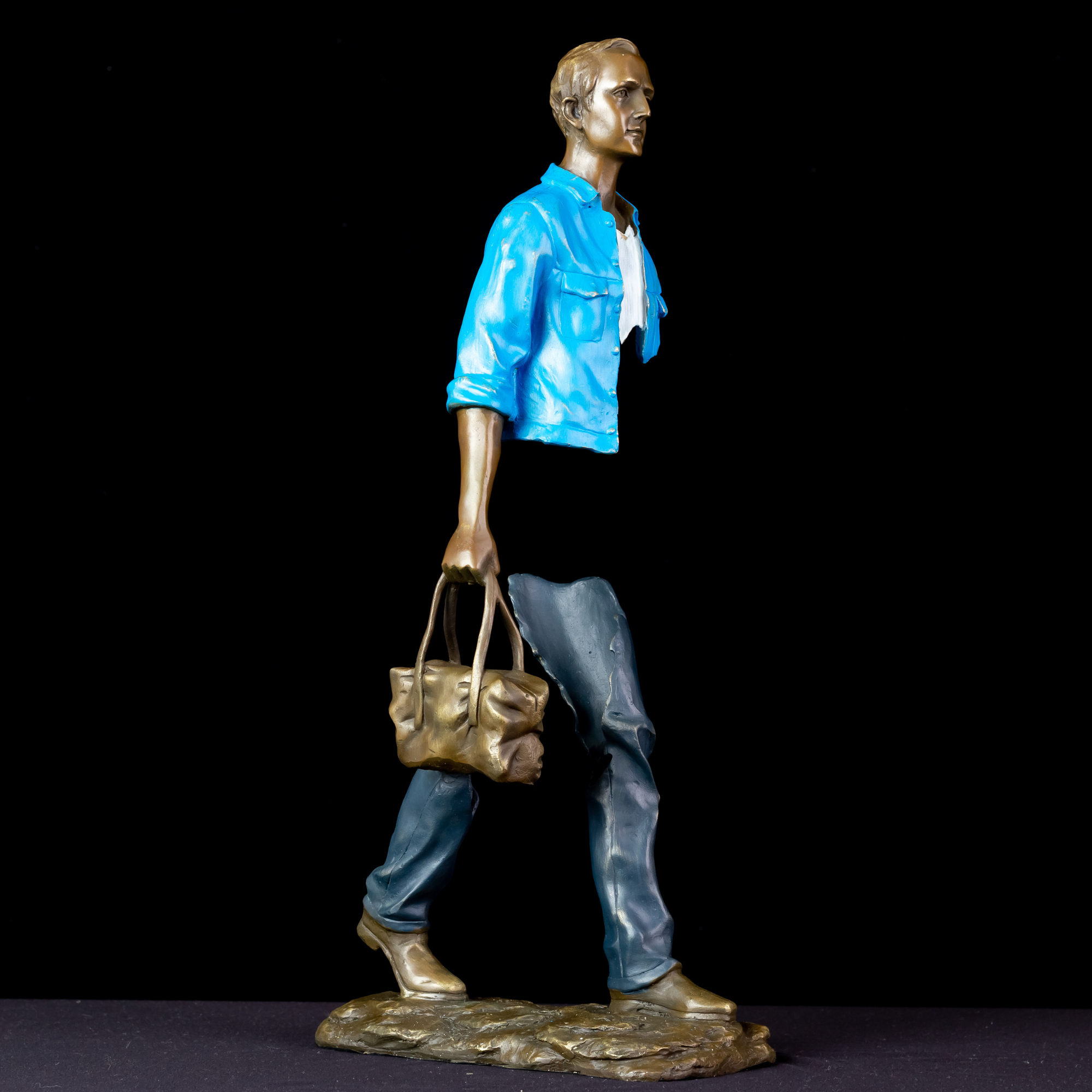 Side view profile of the fragmented surrealist bronze statue in sky light blue.